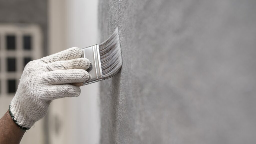 Hand of worker use brush for color paint concrete loft style on wall jpg